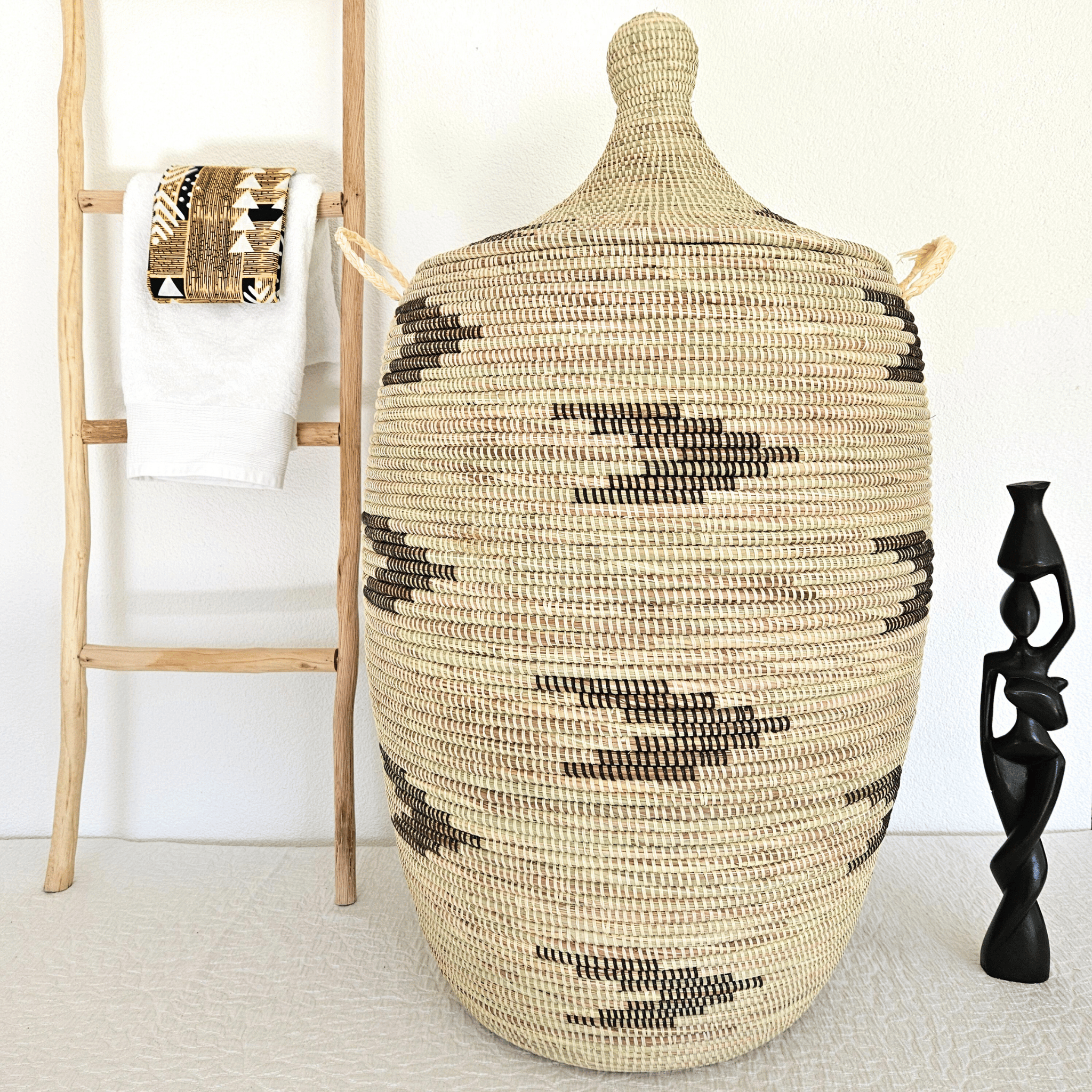 Image d'un grand panier à linge blanc tressé avec motifs noirs avec couvercle et poignées