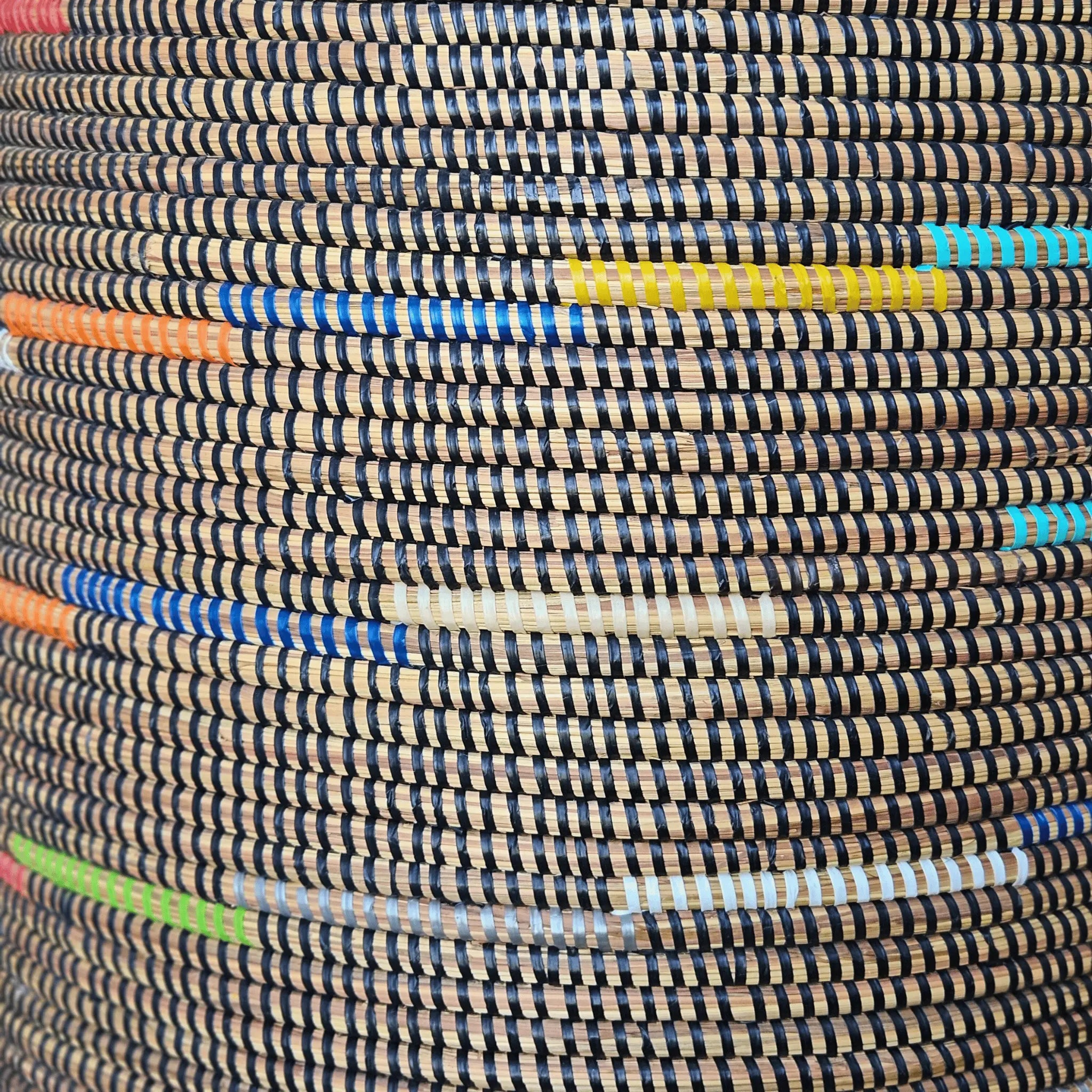 Image du tressage du panier en fibres naturelles noir et couleurs