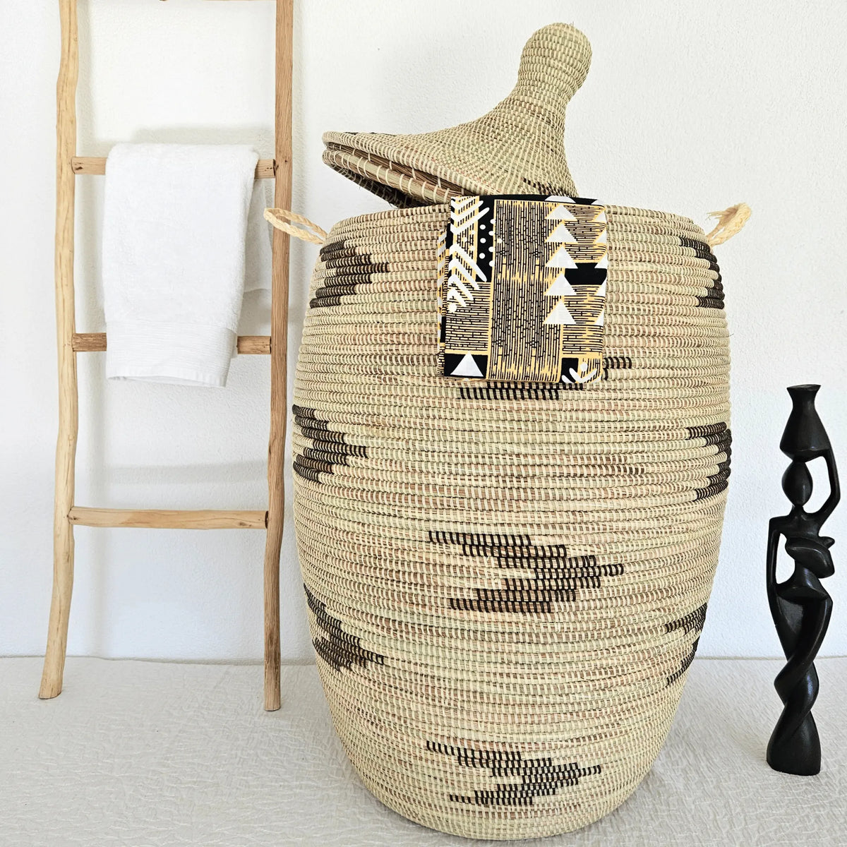 Image d'un grand panier à linge tressé avec couvercle beige avec motifs noirs