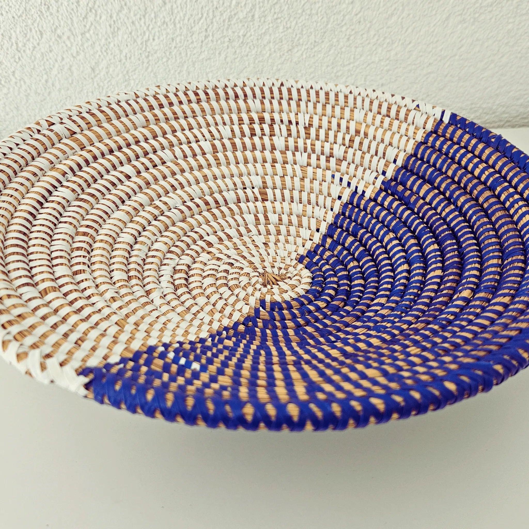 Image d'un panier à fruits ou vide-poche blanc et bleu rond tressé en fibres naturelles