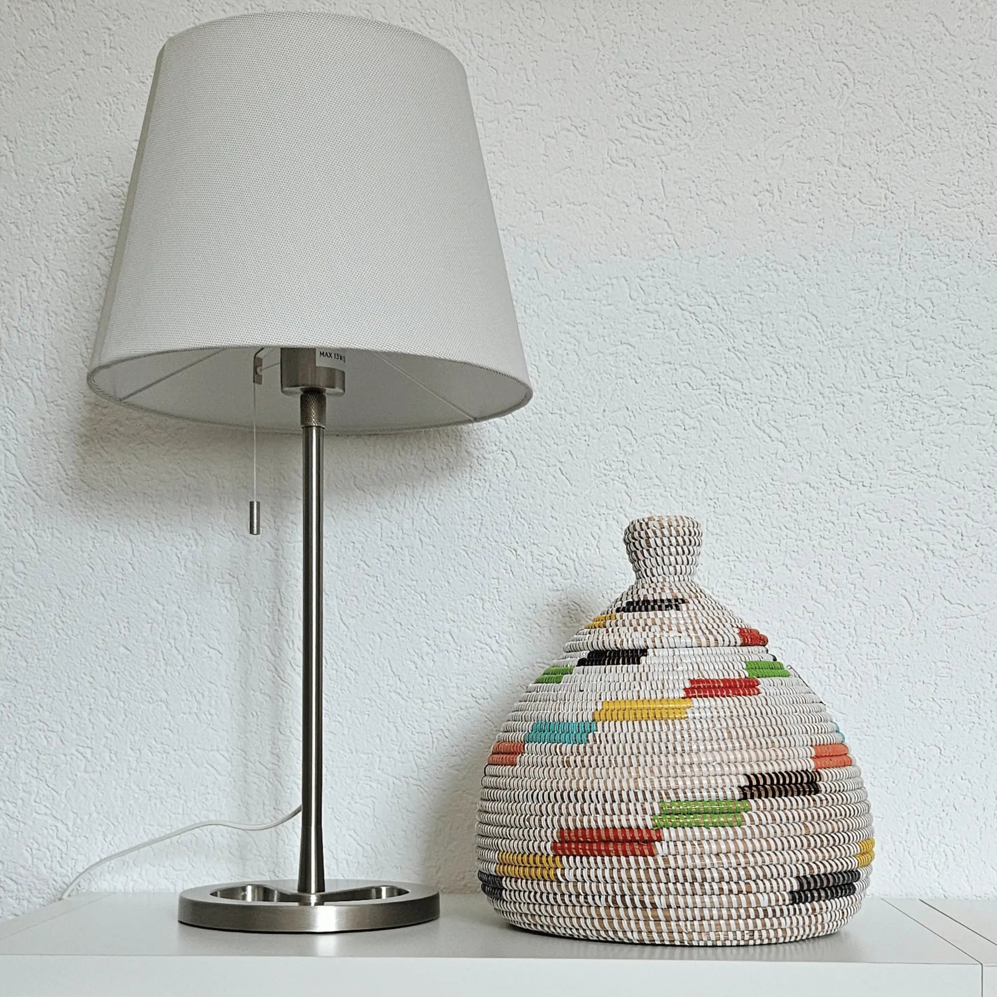 Image d'un panier de décoration rond avec couvercle blanc avec couleurs dans un salon