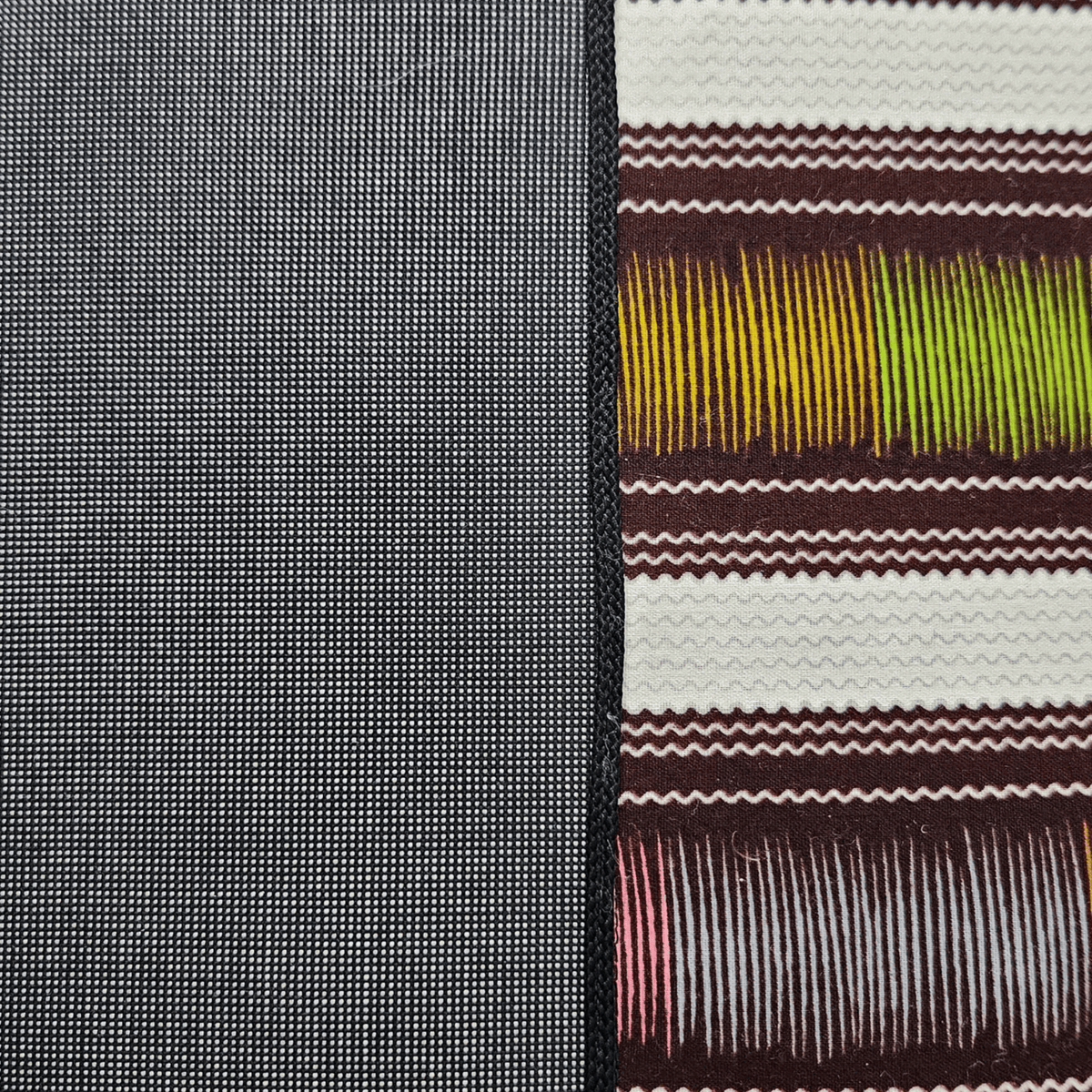 Image des détails d'un coussin en wax multicolore et tissu gris uni