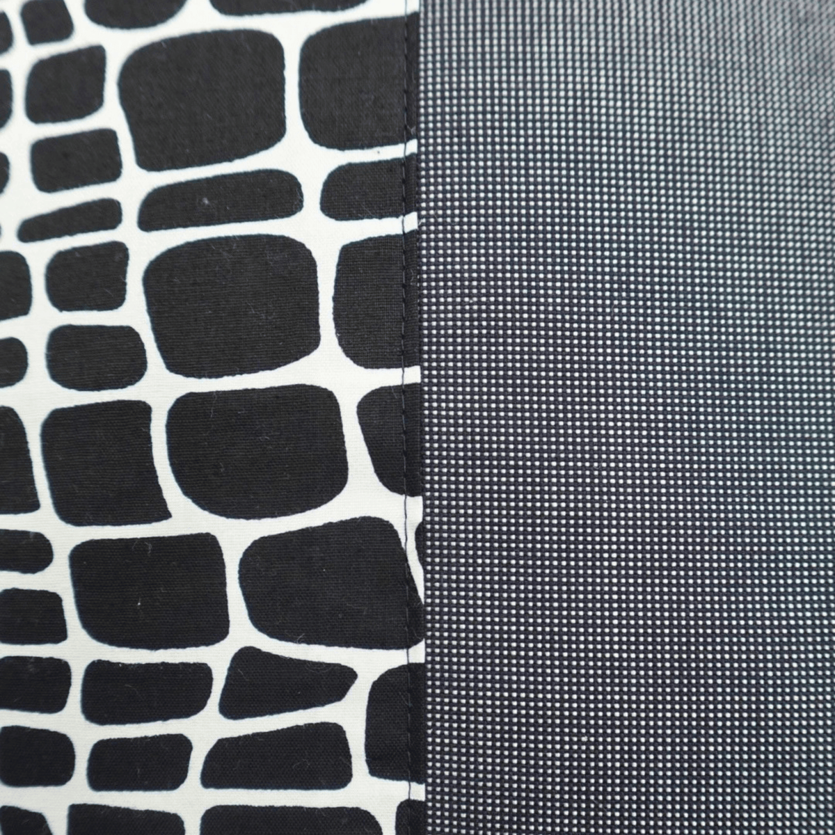Image des détails d'une housse de coussin wax noir et blanc et tissu uni gris