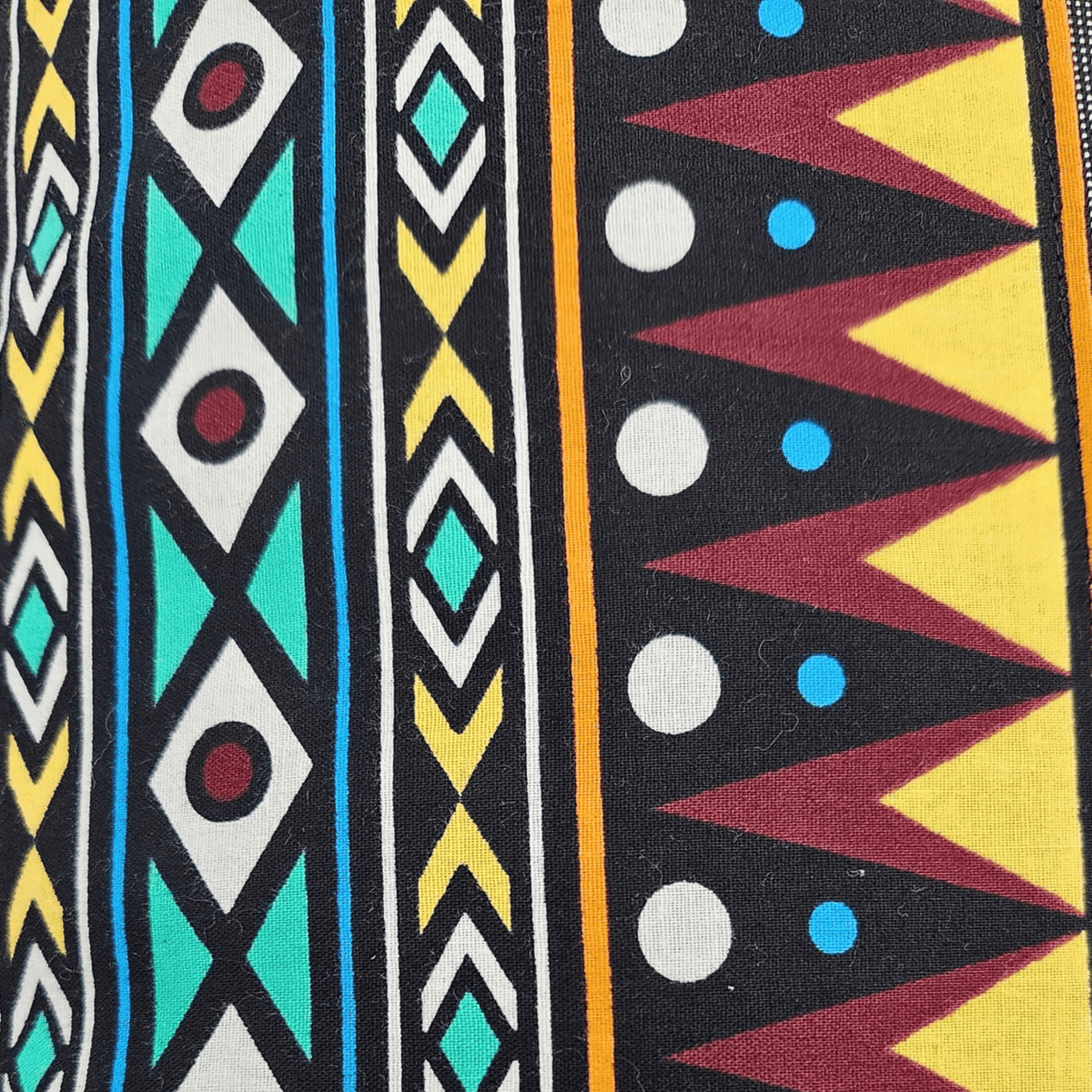 Image des détails d'un tissu wax avec motifs graphiques sur coussin