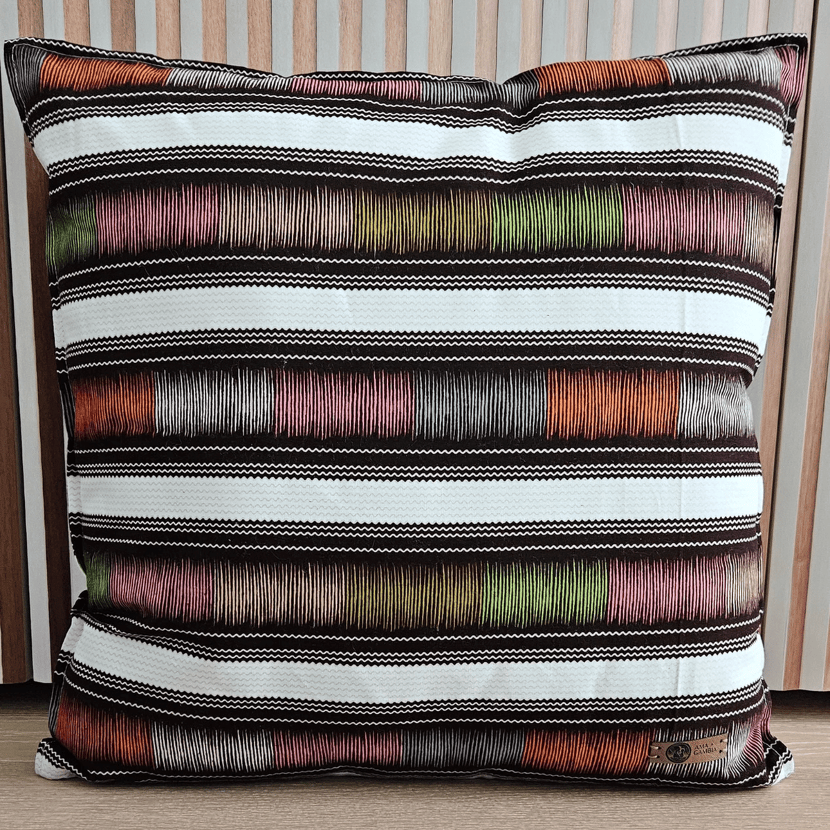 Image d'un coussin en wax africain vert, rose, bleu, orange, noir et blanc